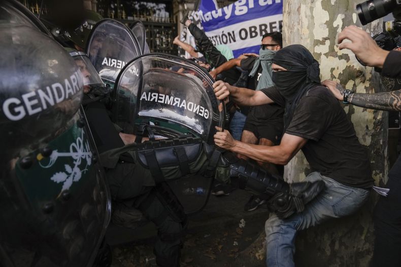 La policía y los manifestantes antigobierno forcejena a las afueras del Congreso donde los legisladores debaten una reforma impulsada por el presidente argentino, Javier Milei, en Buenos Aires, Argentina, el jueves 1 de febrero de 2024. La propuesta incluye una amplia variedad de medidas económicas, administrativas, penales y medioambientales. (AP Foto/Rodrigo Abd)
