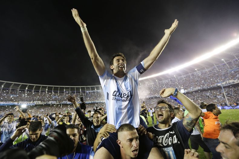 Diego Milito, de Racing, es alzado en hombros durante el festejo por la conquista del t&iacute;tulo de liga en Argentina, el domingo 14 de diciembrre de 2014, en un encuentro ante Godoy Cruz (AP Foto/V&iacute;ctor R. Caivano)