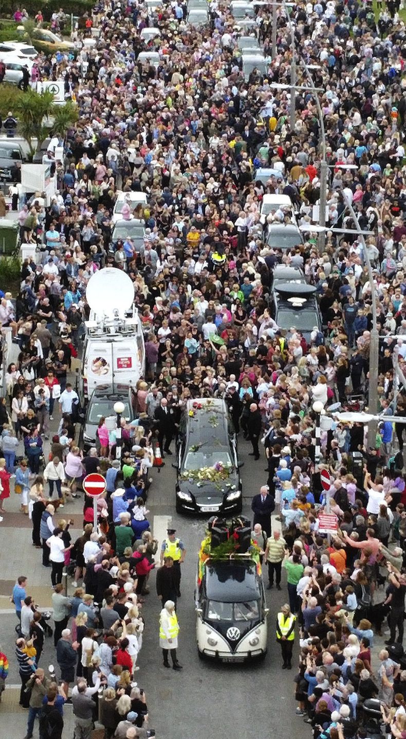 Fans de Sinéad OConnor rodean su cortejo fúnebre en Bray, la ciudad natal de la cantante en el condado de Wicklow, Irlanda, el martes 8 de agosto de 2023. La familia de OConnor invitó al público al paseo marítimo de Bray para despedirse de la artista.(Niall Carson/PA vía AP)