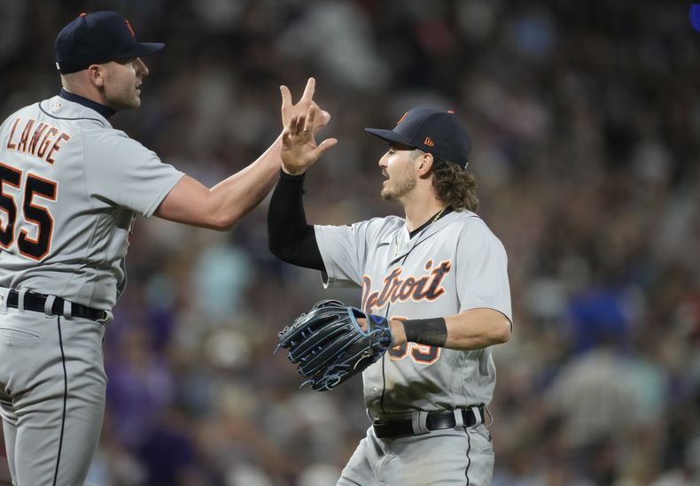 El relevista Alex Lange y el jardinero izquierdo Zach McKinstry de los Tigres de Detroit festejan tras el triunfo del equipo en la décima entrada en el juego ante los Rockies de Colorado el sábado 1 de julio del 2023. (AP Foto/David Zalubowski)