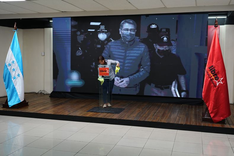 Una pantalla muestra la imagen del expresidente hondureño Juan Orlando Hernández, un día después de que el mandatario estadounidense Donald Trump dijera que planea indultarlo de una sentencia de narcotráfico emitida en 2024, antes del inicio de una conferencia de prensa de la candidata del partido en el poder, Rixi Moncada, en Tegucigalpa, Honduras, el sábado 29 de noviembre de 2025. (AP Foto/Moises Castillo)