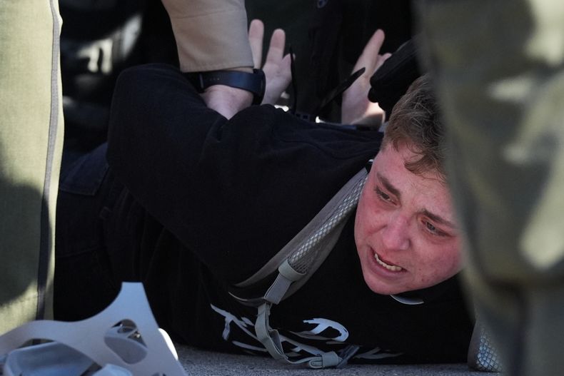 La policía estatal de Illinois detiene a un manifestante afuera de una instalación de procesamiento del Servicio de Inmigración y Control de Aduanas (ICE, por sus siglas en inglés) en el suburbio de Broadview, el viernes 14 de noviembre de 2025, en Chicago, Illinois. (AP Foto/Nam Y. Huh)