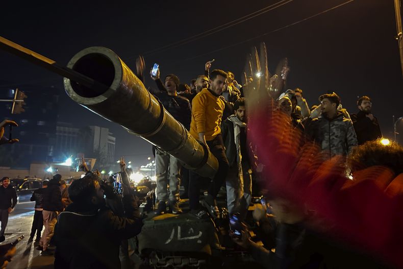 Sirios celebran la llegada de combatientes de oposición a Damasco, Siria, el domingo 8 de diciembre de 2024. (AP Foto/Omar Sanadiki)
