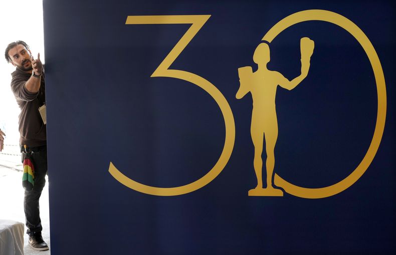 El trabajador Jeremiah Thomas acomoda un fondo durante los preparativos para la alfombra roja de la 30a entrega de los Premios del Sindicato de Actores de la Pantalla que se celebrará el sábado 24 de febrero en una fotografía del jueves 22 de febrero de 2024, en Los Angeles. (Foto AP/Chris Pizzello)