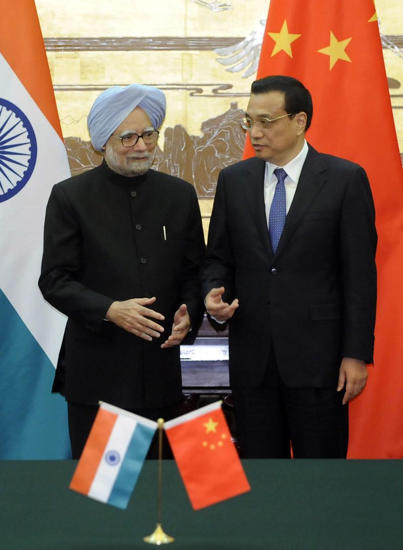 El primer ministro chino Li Keqiang (derecha) habola con su colega de la India, Manmohan Singh, durante la ceremonia de firma de un acuerdo fronterizo en el Gran Sal&oacute;n del Pueblo en Beijing, China, el mi&eacute;rcoles 23 de octubre de 2013. (Foto A