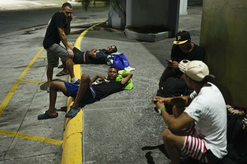 Migrantes venezolanos que regresan del sur de México después de desistir de llegar a Estados Unidos descansan en la calle en la Ciudad de Panamá, el jueves 6 de marzo de 2025. (AP Foto/Matías Delacroix)