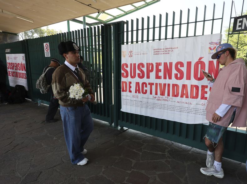 Un hombre con flores en la entrada del Parque Bicentenario en la Ciudad de México el domingo 6 de abril de 2025, después de que el festival AXE Ceremonia fuera suspendido por el colapso de una estructura que mató a dos fotógrafos el día antes. (Foto AP/Ginnette Riquelme)