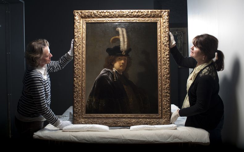 Esta fotograf&iacute;a sin fechar distribuida por el National Trust muestra a las asesoras en pintura Tina Sitwell (izquierda) y Patricia Pertnyk, House Steward sosteniendo un autorretrato de Rembrandt que fue devuelto a la abad&iacute;a Buckland, en Devo