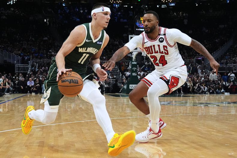 Tyler Herro, izquierda, de los Bucks de Milwaukee, lleva el balón, mientras Norman Powell, derecha, de los Bulls de Chicago, defiende durante la segunda mitad del juego de baloncesto de la NBA, el viernes 23 de octubre de 2026, en Milwaukee. (AP Foto/Nam Y. Huh)