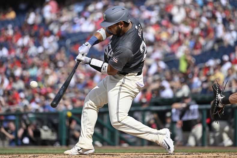 Keibert Ruiz, de los Nacionales de Washington, batea un elevado de sacrificio para impulsar a su compañero Luis García Jr. para una carrera durante la segunda entrada del juego de béisbol contra los Marineros de Seattle, el sábado 25 de mayo de 2024, en Washington. (AP Foto/John McDonnell)