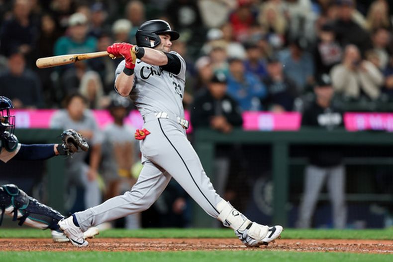 Andrew Benintendi, de los Medias Blancas de Chicago, remolca una carrera en la novena entrada del juego ante los Marineros de Seattle, el martes 19 de mayo de 2026 (AP Foto/Kevin Ng)
