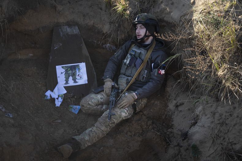 Un soldado de la 1ra brigada Bureviy (Huracán) de la Guardia Nacional de Ucrania, sentado en una trinchera durante una formación de combate en un centro de entrenamiento en el norte de Ucrania, el 3 de noviembre de 2023. (AP Foto/Efrem Lukatsky)