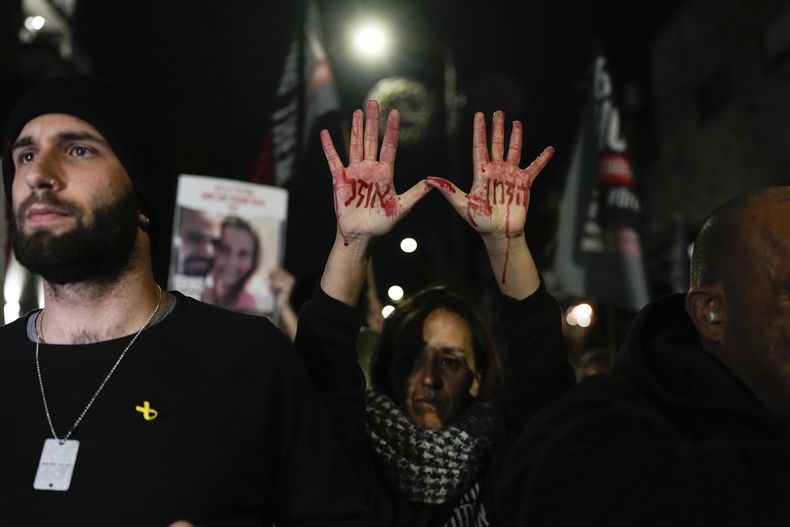 Familiares y partidarios de los rehenes israelíes retenidos por Hamás en Gaza participan en una protesta para exigir su liberación, en el exterior del Knesset, el parlamento israelí, en Jerusalén, el 22 de enero de 2024. La frase escrita con sangre falsa en las manos de la mujer dice El tiempo se acaba, en hebreo. (AP Foto/Ohad Zwigenberg)