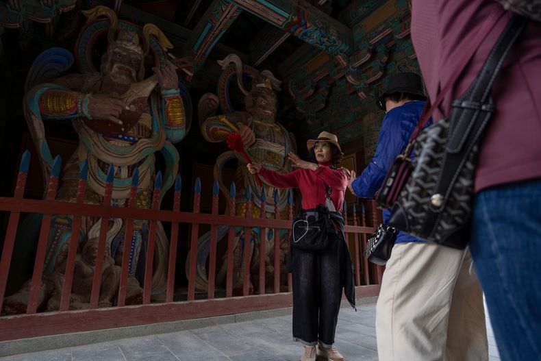 Una guía explica a los visitantes las características del templo Bulguksa mientras se llevan a cabo preparativos para la cumbre del foro de Cooperación Económica Asia-Pacífico (APEC), en Gyeongju, Corea del Sur, el 30 de octubre de 2025. (AP Foto/Ng Han Guan)