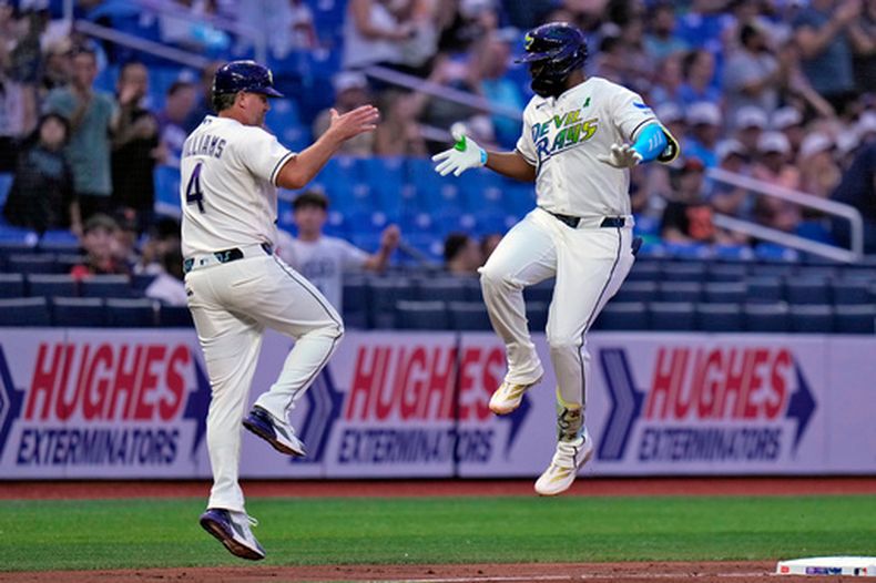 Junior Caminero, derecha, de los Rays de Tampa Bay, celebra su jonrón solitario con el coach de tercera base, Brady Williams (4), durante la cuarta entrada del juego de béisbol de Grandes Ligas frente a los Gigantes de San Francisco, el viernes 1 de mayo de 2026, en San Petersburgo, Florida. (AP Foto/Chris OMeara)