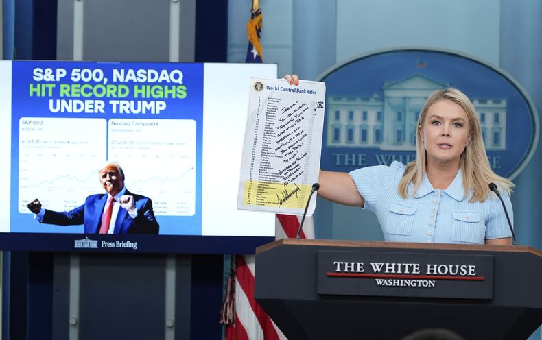 La secretaria de prensa de la Casa Blanca, Karoline Leavitt, sostiene una nota del presidente Donald Trump al presidente de la Reserva Federal, Jerome Powell, escrita en una lista de tasas de bancos centrales de todo el mundo, mientras habla con reporteros en la sala de prensa James Brady de la Casa Blanca, el lunes 30 de junio de 2025, en Washington. (AP Foto/Alex Brandon)