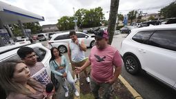 ARCHIVO - Henry Carmona, derecha, que huyó de Venezuela tras recibir amenazas de muerte por negarse a participar en marchas a favor del gobierno de Nicolás Maduro, conversa con amigos tras una conferencia de prensa en que líderes de la comunidad venezolana denunciaron cambios a las normas de protección para cientos de miles de venezolanos, incluyendo a Carmona, de la deportación, el lunes 3 de febrero de 2025, en Doral, Florida. (AP Foto/Rebecca Blackwell, archivo)