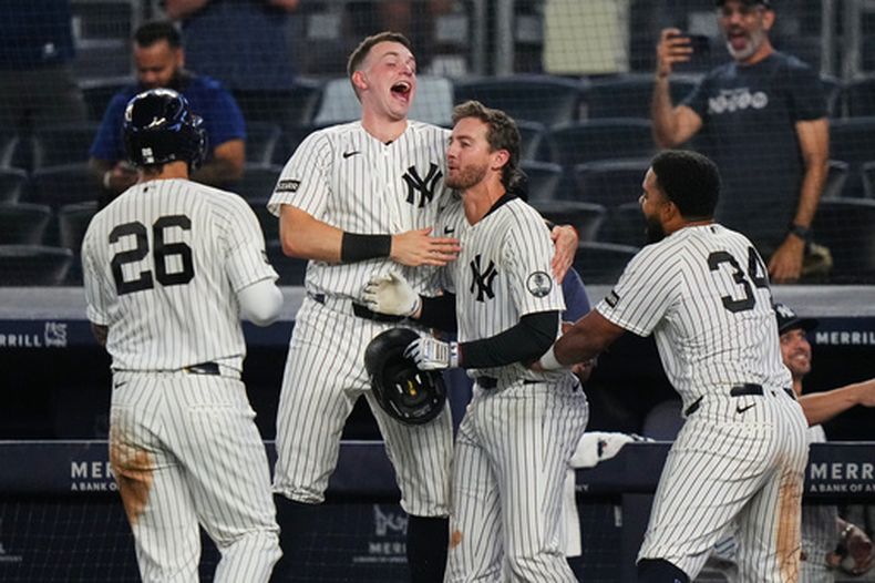 Ryan McMahon (centro), de los Yankees de Nueva York, festeja con sus compañeros, el boricua Heliot Ramos (derecha), Ben Rice (2do de izquierda a derecha) y Luis García Jr., tras la victoria ante los Bravos de Atlanta el sábado 8 de agosto de 2026 (AP Foto/Frank Franklin II)