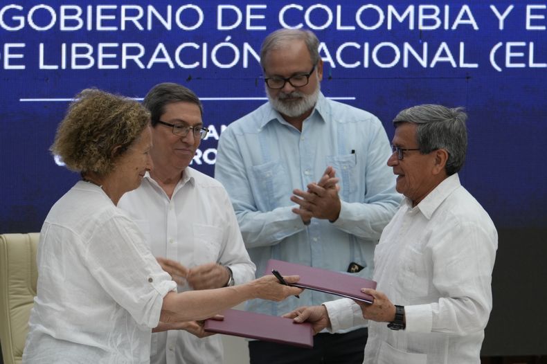 ARCHIVO - La representante del gobierno colombiano Vera Grabe, izquierda, y el comandante colombiano del grupo guerrillero Ejército de Liberación Nacional (ELN), Pablo Beltrán, intercambian su acuerdo firmado de extensión del alto el fuego en La Habana, Cuba, el 6 de febrero de 2024. Detrás está el ministro de Relaciones Exteriores cubano, Bruno Rodríguez, izquierda, y un funcionario cubano no identificado. (AP Foto/Ramón Espinosa, Archivo)