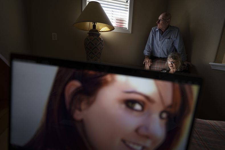 Sandy Phillips y su marido, Lonnie, posan para un retrato en casa de una amiga en Lone Tree, Colorado, el martes 5 de septiembre de 2023, detrás de una foto de su hija, Jessica Ghawi, que murió en la masacre de 2012 en un cine de Aurora, Colorado. Tras sufrir su propia pérdida personal, la pareja se propuso ayudar a otros padres en la misma situación que ellos, viajando a lugares de todo Estados Unidos donde han ocurrido tiroteos. El recorrido continuó durante una década. (AP Foto/David Goldman)