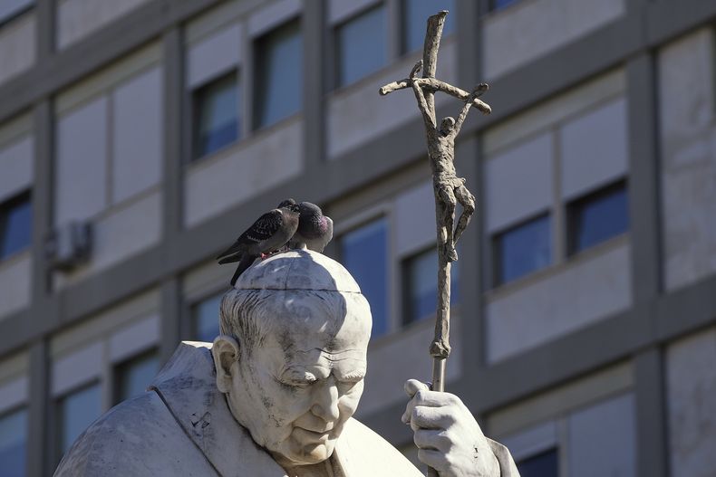 Palomas sobre la estatua del papa Juan Pablo II, ante la Policlínica Agostino Gemelli donde está ingresado el papa Francisco en Roma, el martes 4 de marzo de 2025. (AP Foto/Gregorio Borgia)