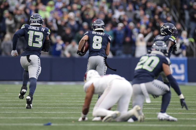 Coby Bryant (8), de los Seahawks de Seattle, se escapa con el balón para anotar un touchdown después de interceptar un pase durante la segunda mitad del partido de la NFL contra los Cardinals de Arizona, el domingo 24 de noviembre de 2024, en Seattle. (AP Foto/Jason Redmond)