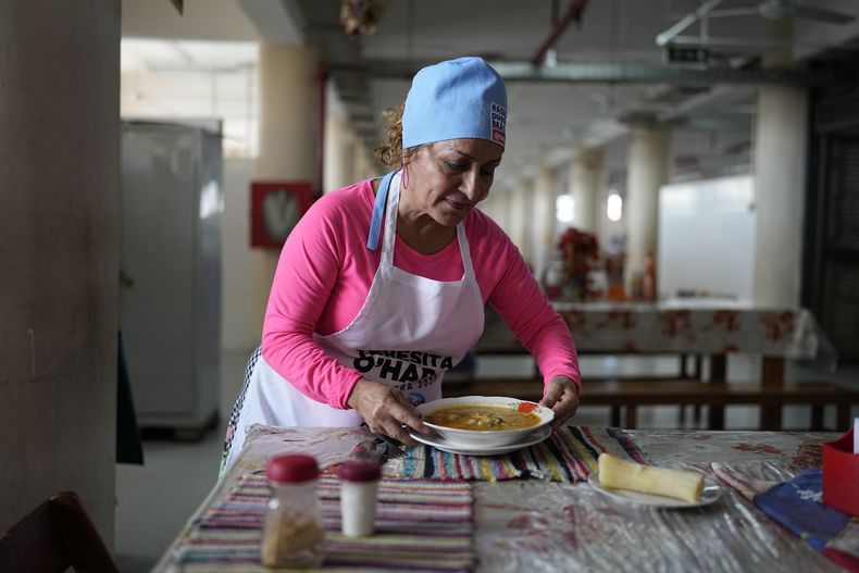 Cristina Barreto, una cocinera de 60 años, pone una mesa para almorzar en el Mercado 4 en Asunción, Paraguay, el jueves 27 de abril de 2023. (AP Foto/Jorge Saenz)