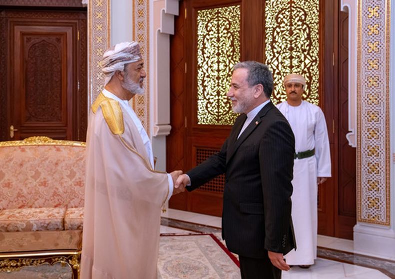 En esta fotografía difundida por el Ministerio de Relaciones Exteriores de Irán, el canciller iraní Abbas Araghchi, derecha, estrecha la mano del sultán de Omán, Haitham bin Tariq, durante su reunión en Mascate, Omán, el domingo 26 de abril de 2026. (Ministerio de Relaciones Exteriores de Irán vía AP)