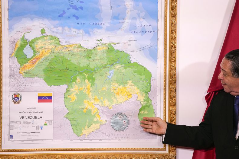 Hermann Escarra, presidente de una comisión venezolana sobre la disputa territorial con Guyana, junto a un mapa en que el Esequibo está integrado al territorio venezolano, en Caracas, Venezuela, el 8 de diciembre del 2023. (AP foto/Matias Delacroix)