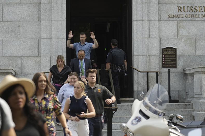 Funcionarios del gobierno salen del edificio de oficinas Russell del Senado, el miércoles 2 de agosto de 2023, en el Capitolio, en Washington, luego de que la policía recibió una llamada sobre una persona armada en el sitio. (AP Foto/J. Scott Applewhite)