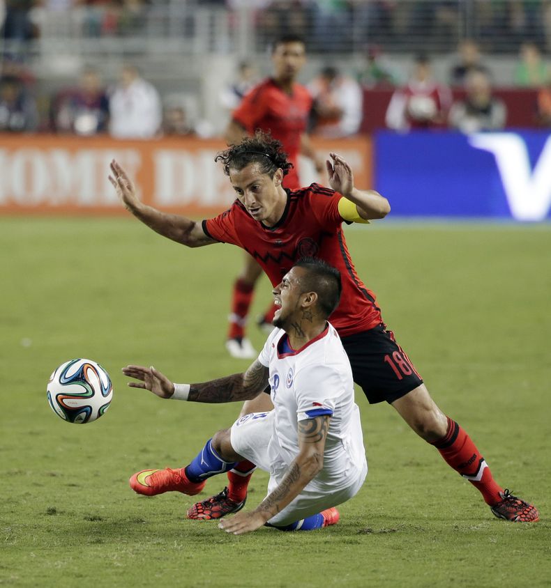 El jugador de la selecci&oacute;n de Chile, Arturo Vidal, abajo, cae en una jugada en un partido contra M&eacute;xico el s&aacute;bado, 6 de septiembre de 2014, en Santa Clara, California. (AP Photo/Marcio Jose Sanchez)