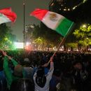Aficionados mexicanos ondean banderas mientras observan el partido de dieciseisavos de final del Mundial entre México y Ecuador cerca del monumento al Ángel de la Independencia en la Ciudad de México, el martes 30 de junio de 2026. (AP Foto/Marco Ugarte)