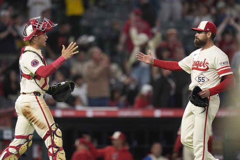 El receptor de los Angelinos de Los Ángeles, Logan OHoppe, a la izquierda, y el relevista Matt Moore se felicitan después de que los Angelinos derrotaron 3-2 a los Padres de San Diego en un juego de béisbol el miércoles 5 de junio de 2024 en Anaheim, California (AP Foto/Mark J. Terrill)