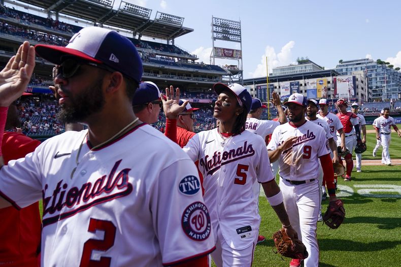 Luis García (2), CJ Abrams (5), Jeimer Candelario (9) y otros celebran la victoria de los Nacionales de Washington ante los Gigantes de San Francisco, el domingo 23 de julio de 20223, en Washington. (AP Foto/Alex Brandon)