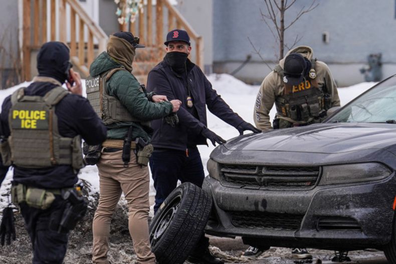 Agentes federales cambian el neumático de un vehículo durante una redada migratoria, el jueves 5 de febrero de 2026, en Minneapolis. (AP Foto/Ryan Murphy)