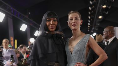 Naomi Campbell, izquierda, y Rosamund Pike posan a su llegada a la 77a entrega de los Premios de la Academia Británica de Cine (BAFTA) en Londres el domingo 18 de febrero de 2024. (Foto Vianney Le Caer/Invision/AP)