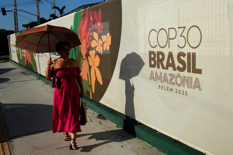 Una mujer pasa por delante de un cartel de la cumbre del clima de Naciones Unidas, COP30, en Belém, en el estado de Pará, Brasil, el 4 de noviembre de 2025. (AP Foto/Eraldo Peres)