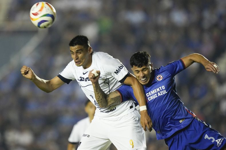 Guillermo Martínez, izquierda, de Pumas, remata de cabeza con la marca defensiva de Carlos Salcedo, de Cruz Azul, durante el partido de vuelta de los cuartos de final del fútbol mexicano, en el estadio Ciudad De Los Deportes, en la Ciudad de México, el domingo 12 de mayo de 2024. (AP Foto/Fernando Llano)