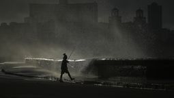 Una persona pesca en el muelle mientras las olas rompen durante un apagón en La Habana, el lunes 21 de octubre de 2024. (AP Foto/Ramón Espinosa)