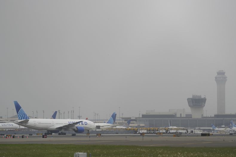 La niebla cubre los aviones y las torres de control del Aeropuerto Internacional Liberty de Newark en Newark, Nueva Jersey, el lunes 5 de mayo de 2025. (AP Foto/Seth Wenig)