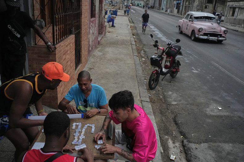 La gente juega dominó al aire libre durante un apagón en La Habana, Cuba, el miércoles 3 de diciembre de 2025. (AP Foto/Ramón Espinosa)