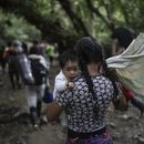 Una migrante boliviana carga un bebé mientras cruza el Tapón del Darién, de Colombia a Panamá, con la esperanza final de llegar a Estados Unidos, el 9 de mayo de 2023. (AP Foto/Iván Valencia)