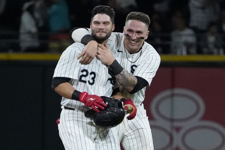 Andrew Benintendi (izquierda), de los Medias Blancas de Chicago, celebra con Korey Lee su sencillo que definió el encuentro ante los Angelinos de Los Ángeles, el miércoles 25 de septiembre de 2024 (AP Foto/David Banks)
