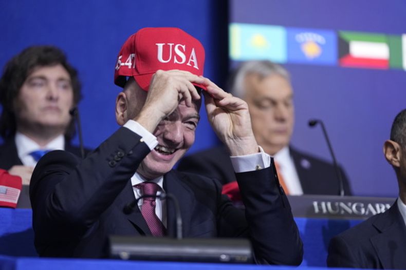 Giovanni Vincenzo Infantino, presidente de la FIFA, se prueba una gorra de USA durante una reunión de la Junta de la Paz en el Instituto de la Paz de los Estados Unidos, el jueves 19 de febrero de 2026, en Washington. (Foto AP/Mark Schiefelbein)