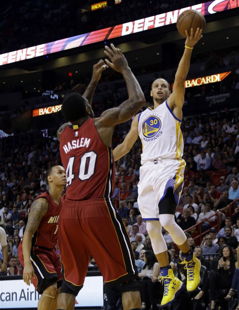 Stephen Curry, de los Warriors de Golden State, dispara frente a Udonis Haslem, del Heat de Miami, durante el duelo del martes 25 de noviembre de 2014 (AP Foto/Lynne Sladky)