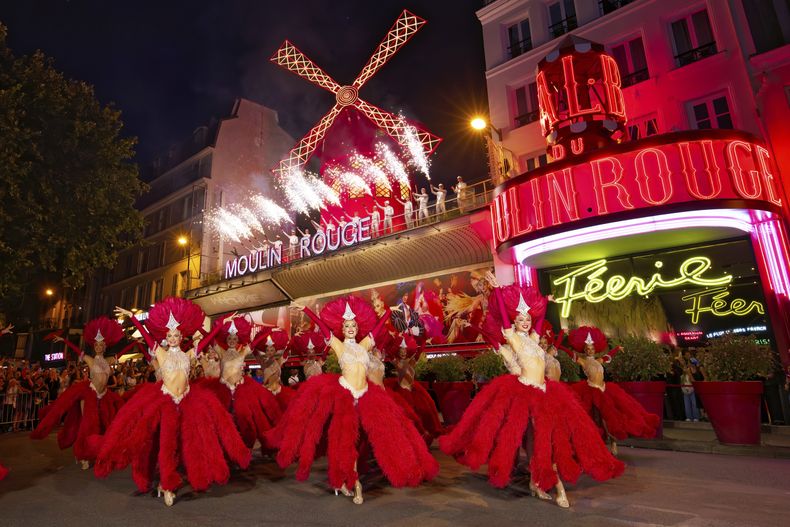 Bailarines actúan afuera del cabaret Moulin Rouge para celebrar la reactivación de las enormes aspas del molino, el jueves 10 de julio de 2025. (Moulin Rouge via AP)