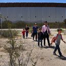 ARCHIVO - Una familia de cinco personas que dice ser de Guatemala y un hombre que dice ser de Perú, con camisa rosa, caminan por el desierto después de cruzar el muro fronterizo en el sector de Tucson de la frontera entre EEUU y México, el 29 de agosto de 2023, cerca de Lukeville, Arizona. (AP Foto/Matt York, Archivo)