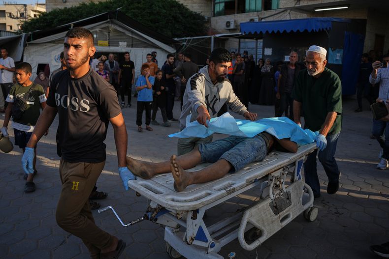 Palestinos trasladan el cuerpo de un hombre que murió por ataques israelíes en la Franja de Gaza a la morgue del Hospital Al-Aqsa en Deir al-Balah, el sábado 22 de noviembre de 2025. (Foto AP/Abdel Kareem Hana)