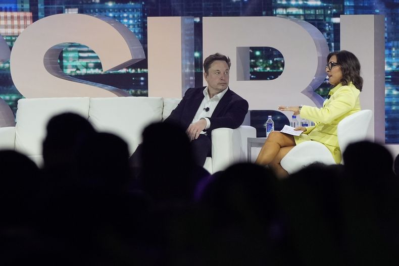 El director general de Twitter, Elon Musk, al centro, conversa con Linda Yaccarino, presidenta de publicidad global y asociaciones de NBC, en la conferencia de comercialización POSSIBLE en Miami Beach, Florida, el martes 18 de abril de 2023. (AP Foto/Rebecca Blackwell)