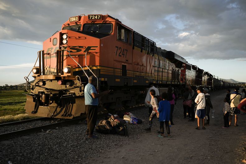 Migrantes ven pasar un tren mientras esperan a lo largo de las vías con la esperanza de subir a un tren de carga que vaya hacia el norte, uno que se detenga el tiempo suficiente para que puedan subirse, el 19 de septiembre de 2023, en Huehuetoca, México. (AP Foto/Eduardo Verdugo)